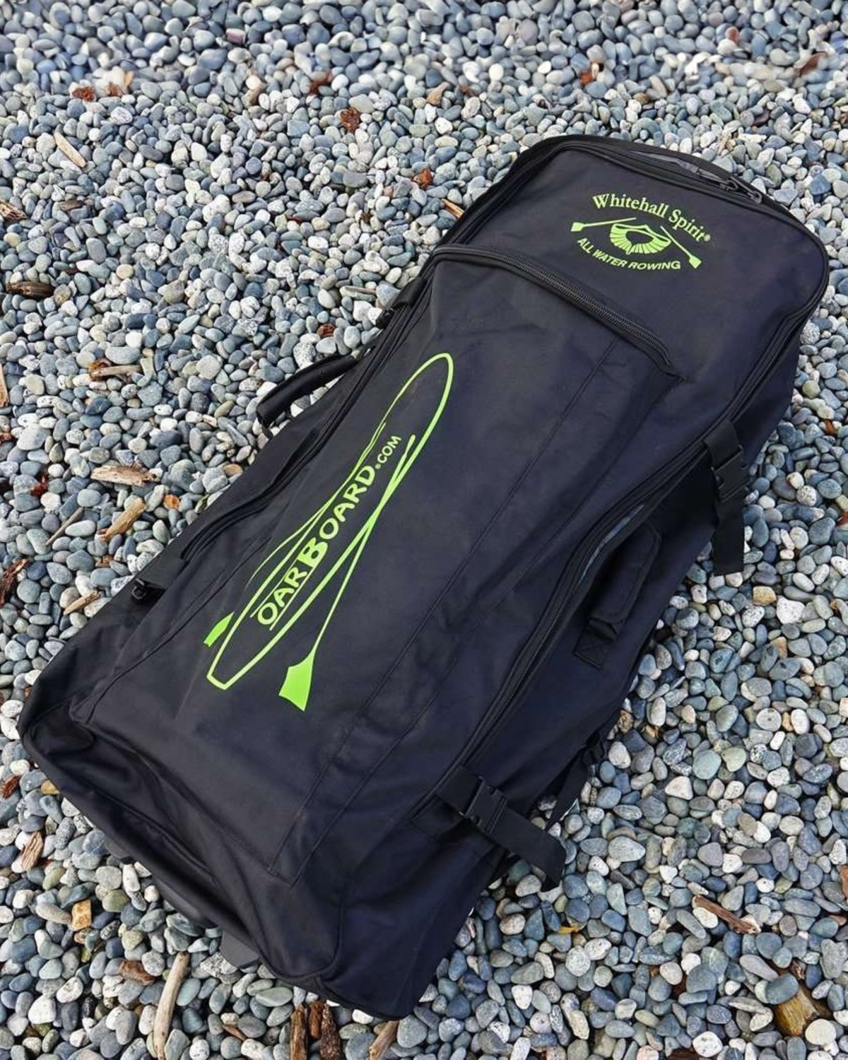 A black bag with lime green branding, placed on a bed of gray and white gravel. The bag features a large vertical oar board logo.