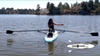 A step by step video where a woman dressed all in all black, wearing sunglasses demonstrates how to row on the Oar Board SUP Rower.