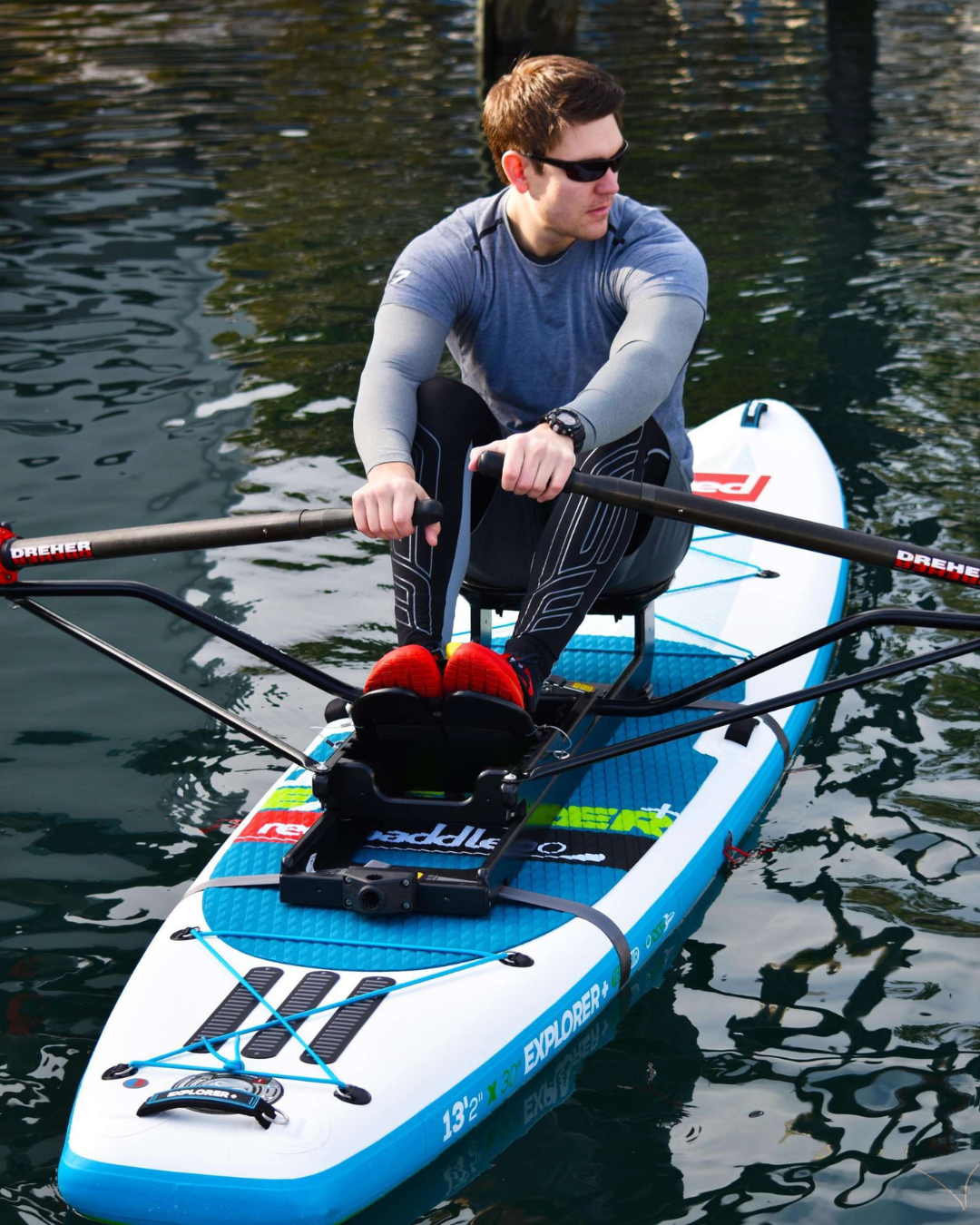 A man rowing the oar board rowing kit on a inflatable paddle board.