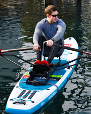 A man rowing the oar board rowing kit on a inflatable paddle board.